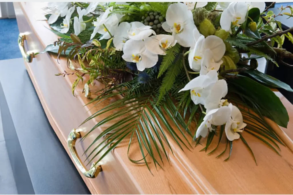 Composition florale d'orchidées blanches sur un cercueil en bois
