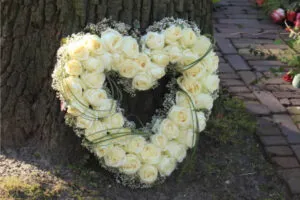 Couronne funéraire en forme de cœur composée de roses blanches